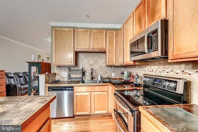 644 Luthardt Rd, Middle River, MD 21220 - kitchen featuring stainless steel appliances, crown molding, a sink, decorative backsplash, and light wood finished floors
