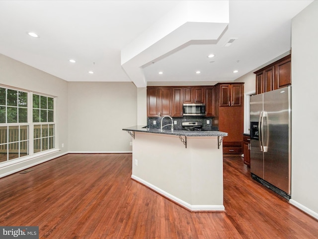 11937 Saint Francis Way, Bowie, MD 20721 - kitchen with stainless steel appliances, a breakfast bar, dark wood-style floors, backsplash, and recessed lighting