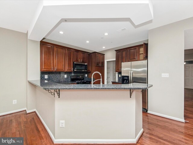 11937 Saint Francis Way, Bowie, MD 20721 - kitchen with appliances with stainless steel finishes, light wood finished floors, a peninsula, a kitchen bar, and recessed lighting