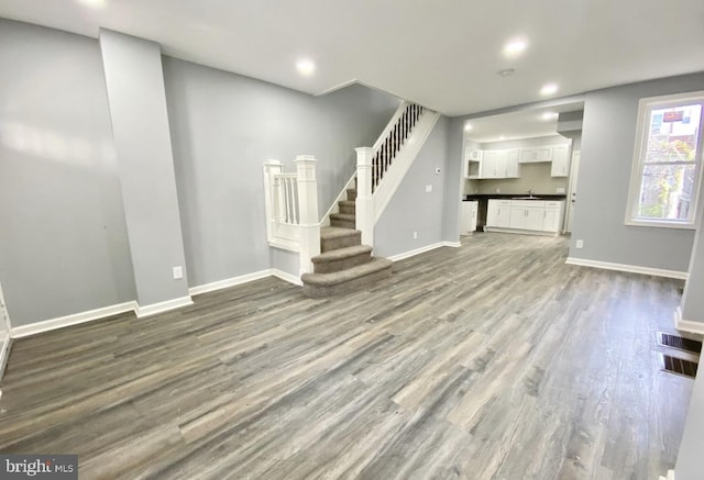 2922 W Norris St, Philadelphia, PA 19121 - unfurnished living room with wood finished floors, stairs, baseboards, a sink, and recessed lighting