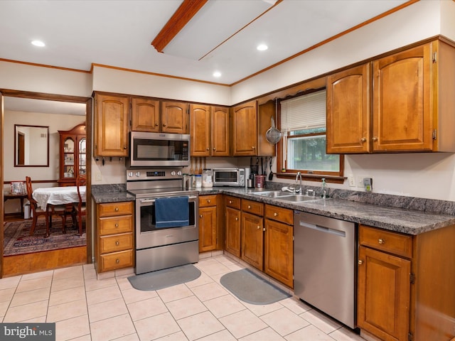 1112 Stromko Dr, Fallston, MD 21047 - kitchen with appliances with stainless steel finishes, a sink, brown cabinets, dark countertops, and ornamental molding