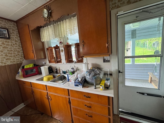 817 Maple St, Waynesboro, PA 17268 - kitchen with light countertops, crown molding, a sink, brown cabinets, and wallpapered walls