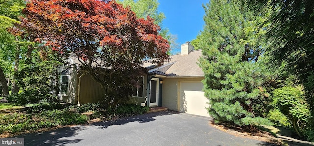 1821 Driver Ave, Lancaster, PA 17602 - obstructed view of property with an attached garage, driveway, a chimney, and brick siding