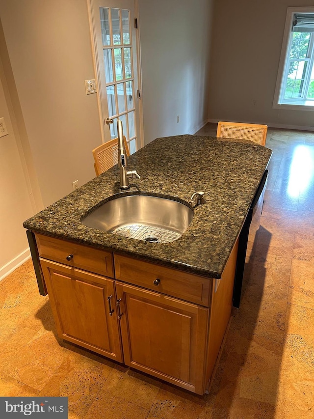 1821 Driver Ave, Lancaster, PA 17602 - kitchen featuring a sink, dishwashing machine, brown cabinetry, a kitchen island with sink, and dark stone countertops