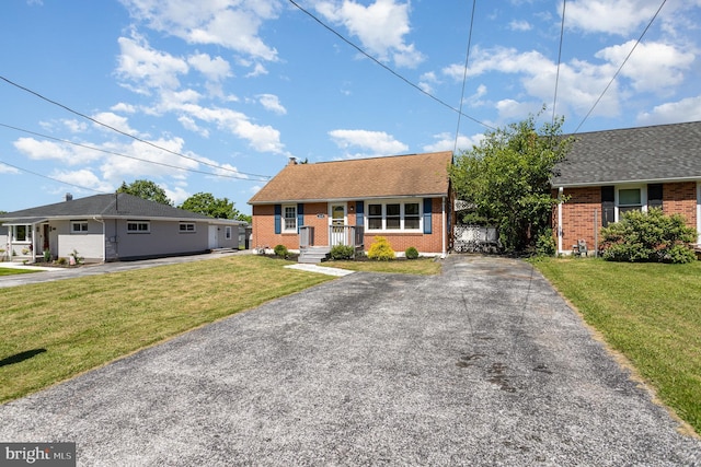 2269 Locust Ln, York, PA 17408 - view of front of home with brick siding, asphalt driveway, a front lawn, and roof with shingles