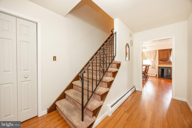 306 Spring Cir, Norristown, PA 19403 - stairs with baseboard heating, wood finished floors, and baseboards