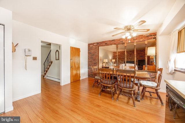 306 Spring Cir, Norristown, PA 19403 - dining space with a baseboard heating unit, a ceiling fan, brick wall, light wood-style flooring, and stairway