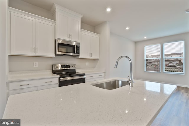 488 National St, Ranson, WV 25438 - kitchen featuring stainless steel appliances, a sink, white cabinets, recessed lighting, and wood finished floors