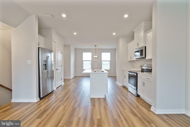 488 National St, Ranson, WV 25438 - kitchen featuring appliances with stainless steel finishes, white cabinetry, a sink, baseboards, and a center island with sink