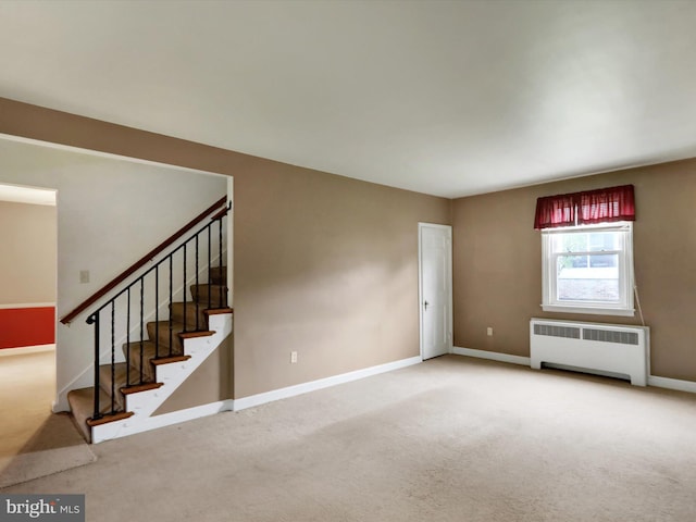 1411 College Ave, Reading, PA 19604 - unfurnished living room featuring radiator heating unit, carpet, baseboards, and stairs