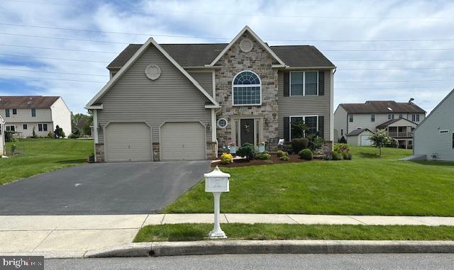 310 Valley Ct, Reading, PA 19608 - view of front of house featuring asphalt driveway, stone siding, and a front yard