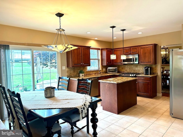310 Valley Ct, Reading, PA 19608 - kitchen featuring appliances with stainless steel finishes, a center island, light tile patterned floors, decorative backsplash, and pendant lighting