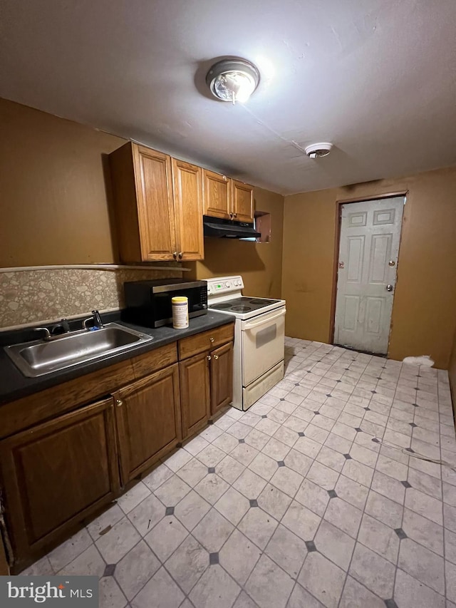 2074 E Clementine St, Philadelphia, PA 19134 - kitchen featuring electric stove, a sink, under cabinet range hood, stainless steel microwave, and dark countertops