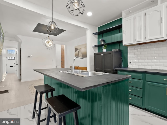 2002 E Preston St, Baltimore, MD 21213 - kitchen featuring dark countertops, a sink, white cabinetry, backsplash, and light marble finish floors