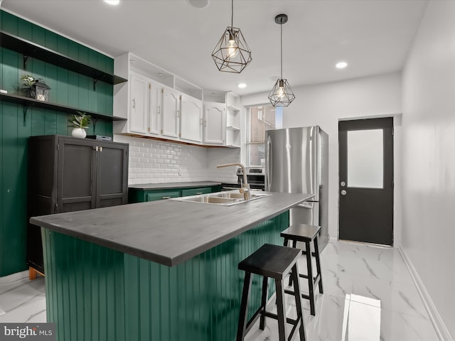 2002 E Preston St, Baltimore, MD 21213 - kitchen featuring open shelves, light marble finish floors, baseboards, freestanding refrigerator, and a sink