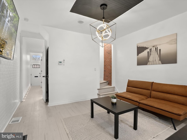 2002 E Preston St, Baltimore, MD 21213 - living area featuring light wood-type flooring, stairway, and a chandelier