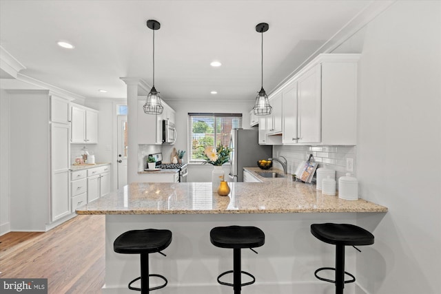 3017 Fulton St, Alexandria, VA 22305 - kitchen featuring stainless steel appliances, a peninsula, white cabinets, backsplash, and recessed lighting