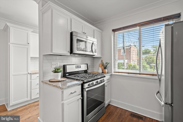 3017 Fulton St, Alexandria, VA 22305 - kitchen with stainless steel appliances, crown molding, white cabinetry, light wood-type flooring, and backsplash