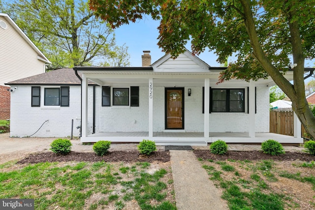 2920 Weisman Rd, Silver Spring, MD 20902 - view of front facade featuring covered porch, a chimney, and brick siding
