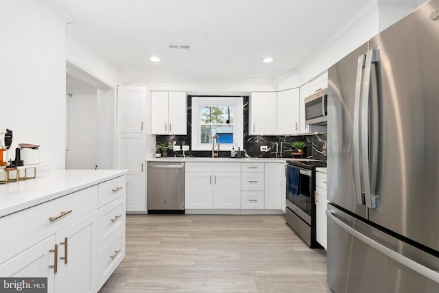 2920 Weisman Rd, Silver Spring, MD 20902 - kitchen with stainless steel appliances, decorative backsplash, white cabinetry, a sink, and crown molding