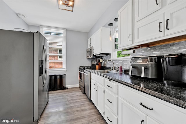 619 Warwick Rd, Baltimore, MD 21229 - kitchen with stainless steel appliances, a sink, white cabinetry, tasteful backsplash, and baseboards