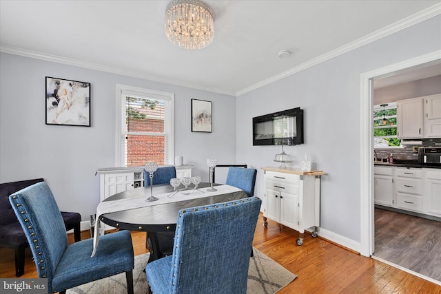 619 Warwick Rd, Baltimore, MD 21229 - dining room featuring crown molding, light wood-style floors, plenty of natural light, a chandelier, and baseboards