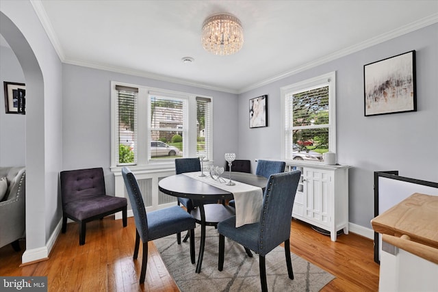 619 Warwick Rd, Baltimore, MD 21229 - dining space with arched walkways, healthy amount of natural light, ornamental molding, and light wood finished floors