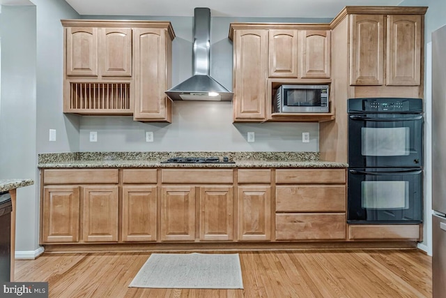 141 Lorins Dr, Huntingtown, MD 20639 - kitchen featuring wall chimney range hood, stainless steel microwave, light wood-type flooring, and light stone counters