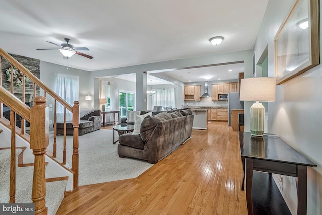 141 Lorins Dr, Huntingtown, MD 20639 - living room with light wood finished floors, a ceiling fan, and stairway