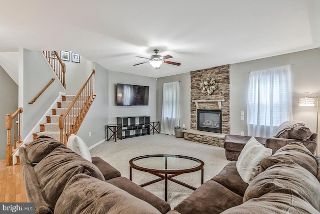 141 Lorins Dr, Huntingtown, MD 20639 - living area with a fireplace, stairs, a ceiling fan, baseboards, and light carpet
