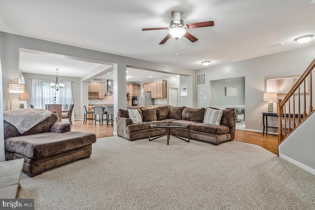 141 Lorins Dr, Huntingtown, MD 20639 - living area with ceiling fan, stairway, a chandelier, baseboards, and light carpet