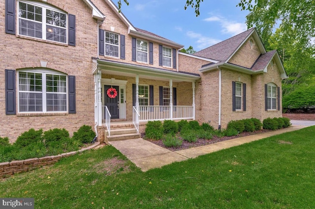 141 Lorins Dr, Huntingtown, MD 20639 - traditional-style home with a porch, a front lawn, brick siding, and a shingled roof