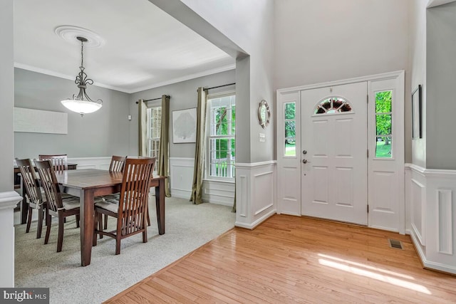 141 Lorins Dr, Huntingtown, MD 20639 - foyer featuring light wood-style flooring, wainscoting, a decorative wall, and crown molding