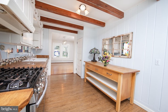 8 S Main St, Stockton, NJ 08559 - kitchen featuring butcher block countertops, light wood-style floors, beamed ceiling, stainless steel gas range oven, and a sink