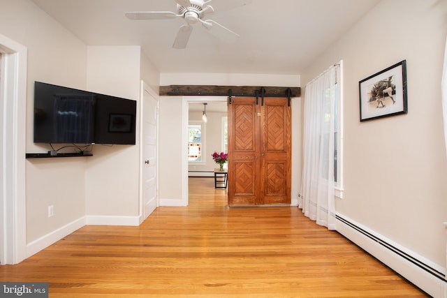 8 S Main St, Stockton, NJ 08559 - unfurnished living room featuring light wood-style flooring, a baseboard radiator, a barn door, baseboards, and ceiling fan