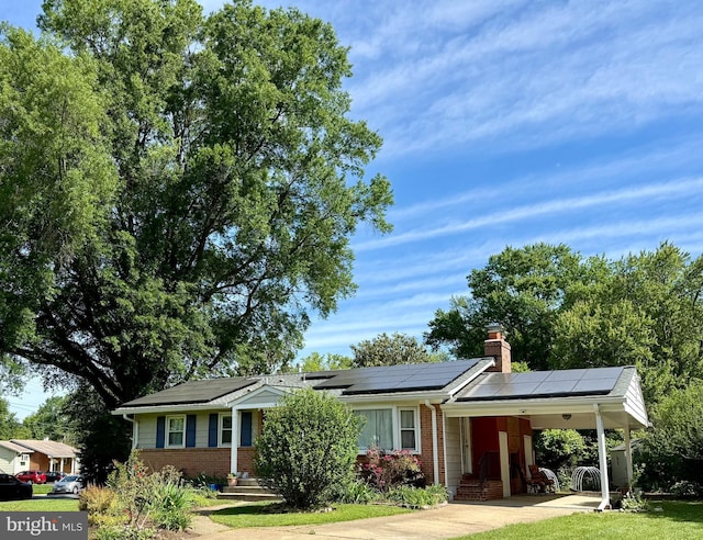 8230 Citadel Pl, Vienna, VA 22180 - ranch-style home with brick siding, an attached carport, roof mounted solar panels, and a chimney