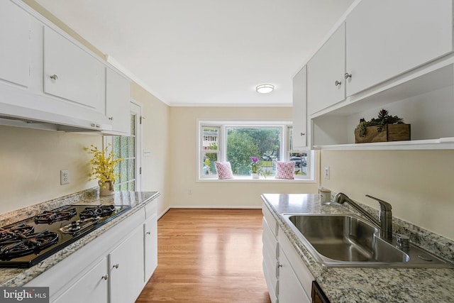 8230 Citadel Pl, Vienna, VA 22180 - kitchen with black gas stovetop, a sink, range hood, light wood-style floors, and white cabinets