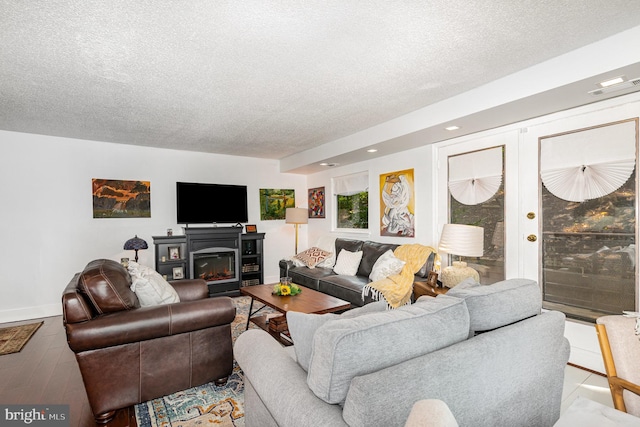1040 Deer Ridge Dr Unit 101, Baltimore, MD 21210 - living room featuring a textured ceiling, wood finished floors, baseboards, recessed lighting, and a glass covered fireplace