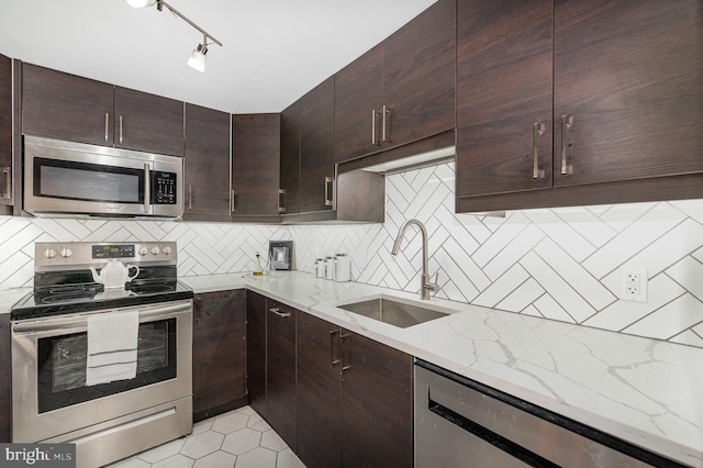 1040 Deer Ridge Dr Unit 101, Baltimore, MD 21210 - kitchen with stainless steel appliances, a sink, decorative backsplash, light stone countertops, and dark brown cabinets