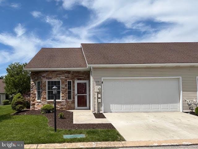 636 Northland Dr, Hanover, PA 17331 - view of front of house featuring concrete driveway, an attached garage, stone siding, and a front lawn