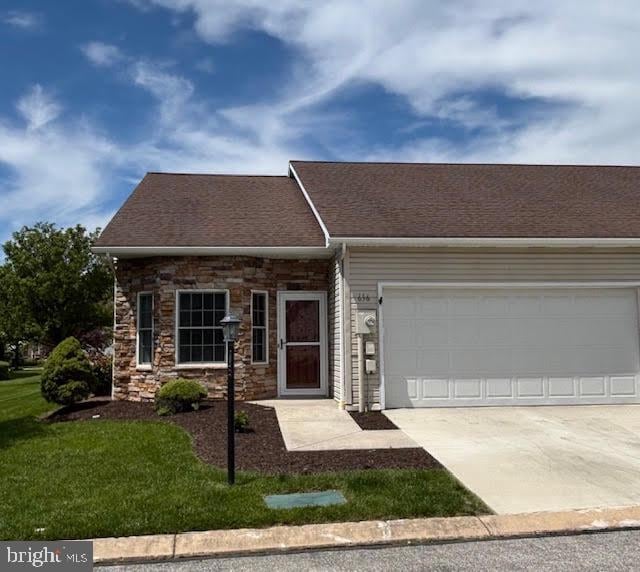 636 Northland Dr, Hanover, PA 17331 - view of front facade with driveway, a garage, stone siding, a front lawn, and roof with shingles
