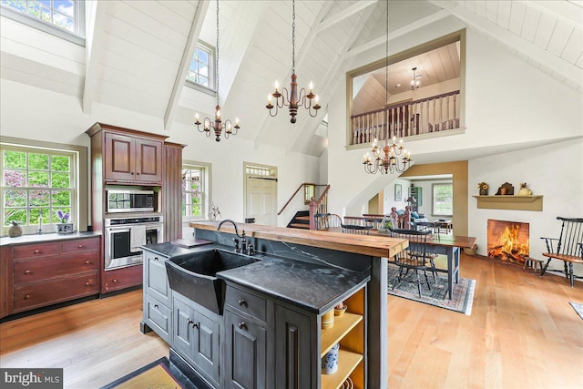103 Orchard Hill Ln, Elverson, PA 19520 - kitchen featuring appliances with stainless steel finishes, a sink, a chandelier, high vaulted ceiling, and light wood-type flooring