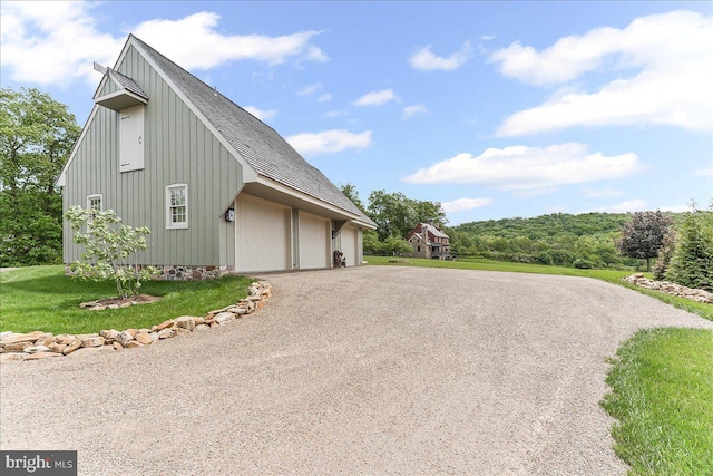 103 Orchard Hill Ln, Elverson, PA 19520 - view of home's exterior with a garage, asphalt driveway, a shingled roof, a lawn, and board and batten siding