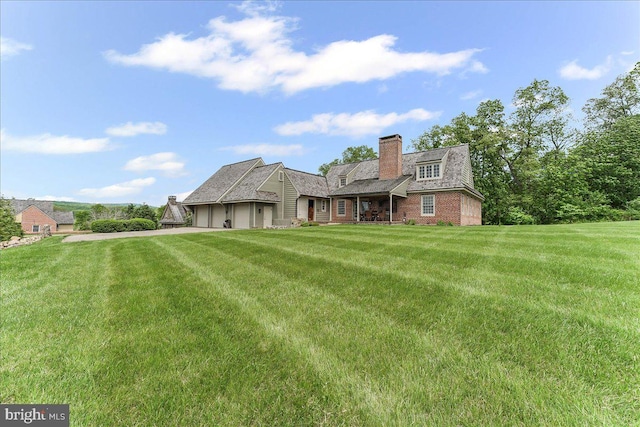 103 Orchard Hill Ln, Elverson, PA 19520 - rear view of property with an attached garage, a yard, and a chimney