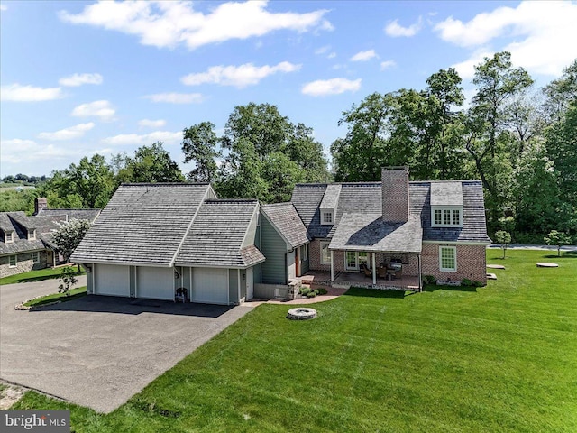 103 Orchard Hill Ln, Elverson, PA 19520 - view of front of house featuring a front lawn, asphalt driveway, brick siding, a chimney, and a garage
