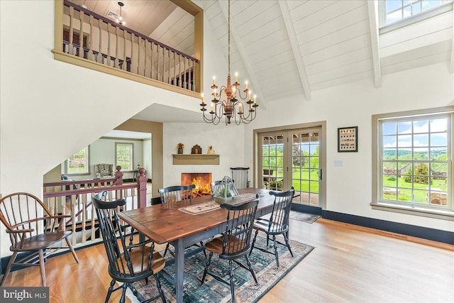 103 Orchard Hill Ln, Elverson, PA 19520 - dining space with wood finished floors, a chandelier, a warm lit fireplace, wooden ceiling with exposed beams, and baseboards