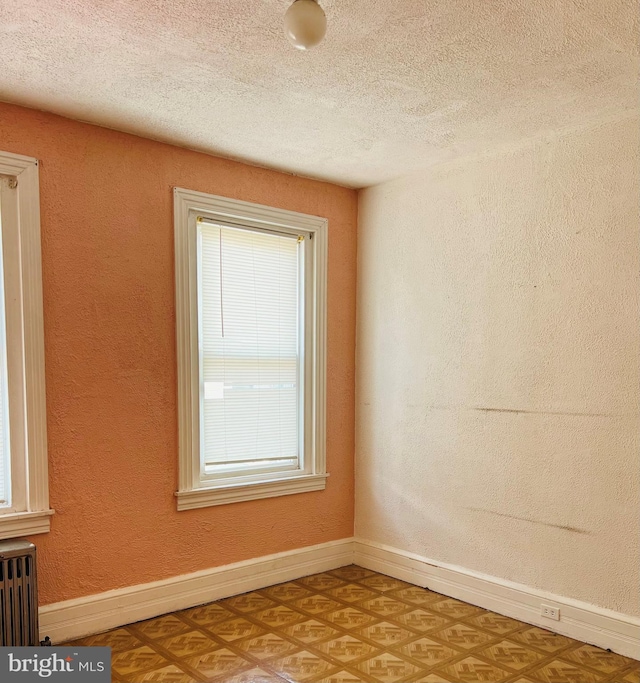 735 Locust St, Reading, PA 19604 - spare room featuring radiator heating unit, a textured ceiling, and baseboards