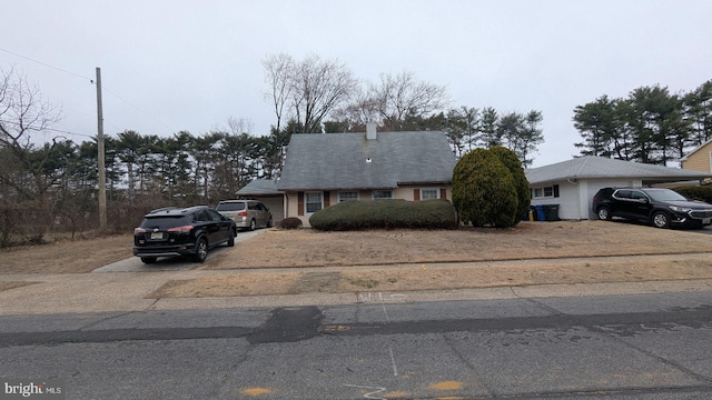 71 Shawmont Ln, Willingboro, NJ 08046 - view of front of house with driveway, an attached garage, and a chimney