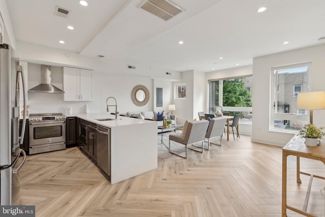 1214 Queen St NE Unit 2, Washington, DC 20002 - kitchen featuring appliances with stainless steel finishes, wall chimney range hood, a sink, a peninsula, and open floor plan