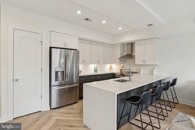 1214 Queen St NE Unit 2, Washington, DC 20002 - kitchen featuring stainless steel fridge, wall chimney exhaust hood, a peninsula, a breakfast bar, and white cabinets